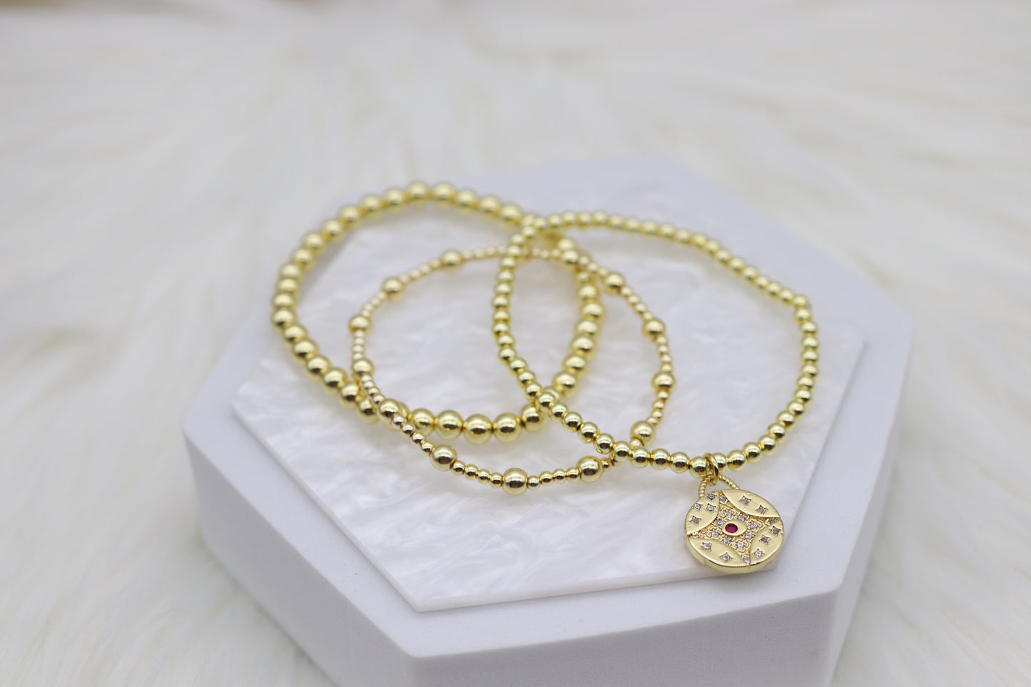 Triple Layered Gold Beaded Bracelet With Red Diamond Star Dangling Pendant