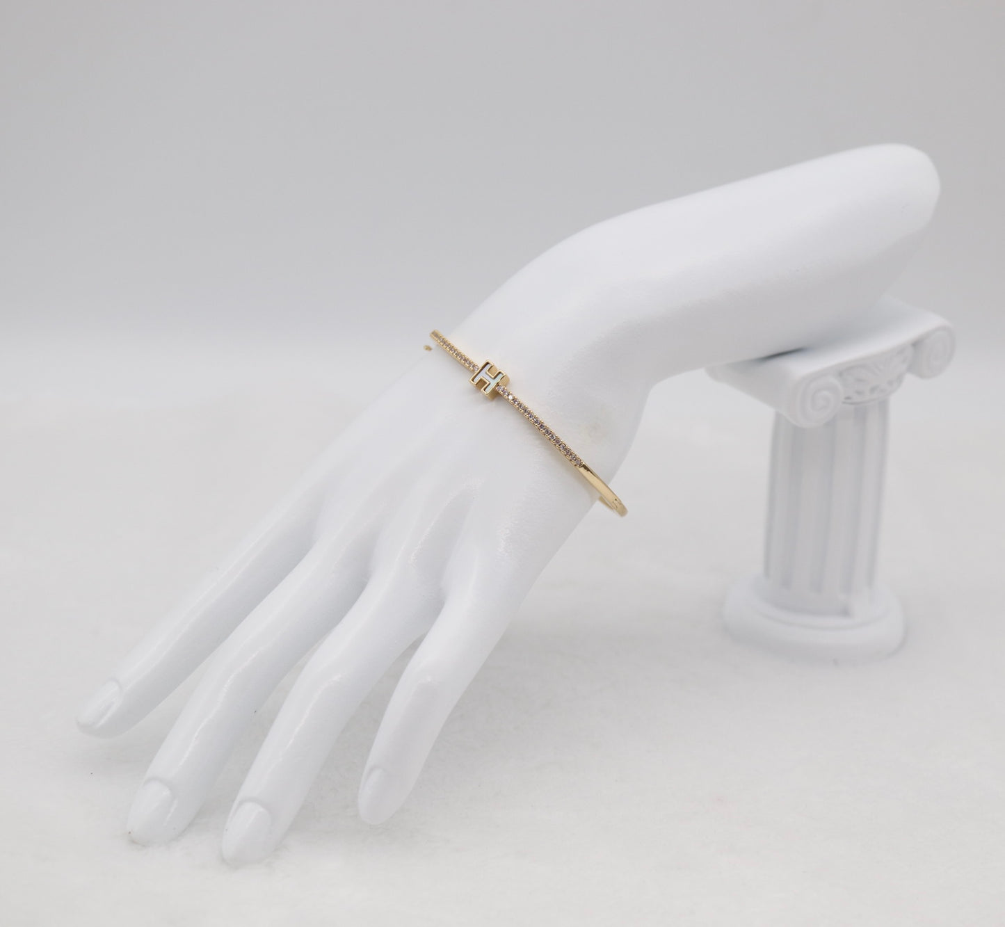 Gold-Tone Hinged Bangle with Crystal Accents and “H” Centerpiece