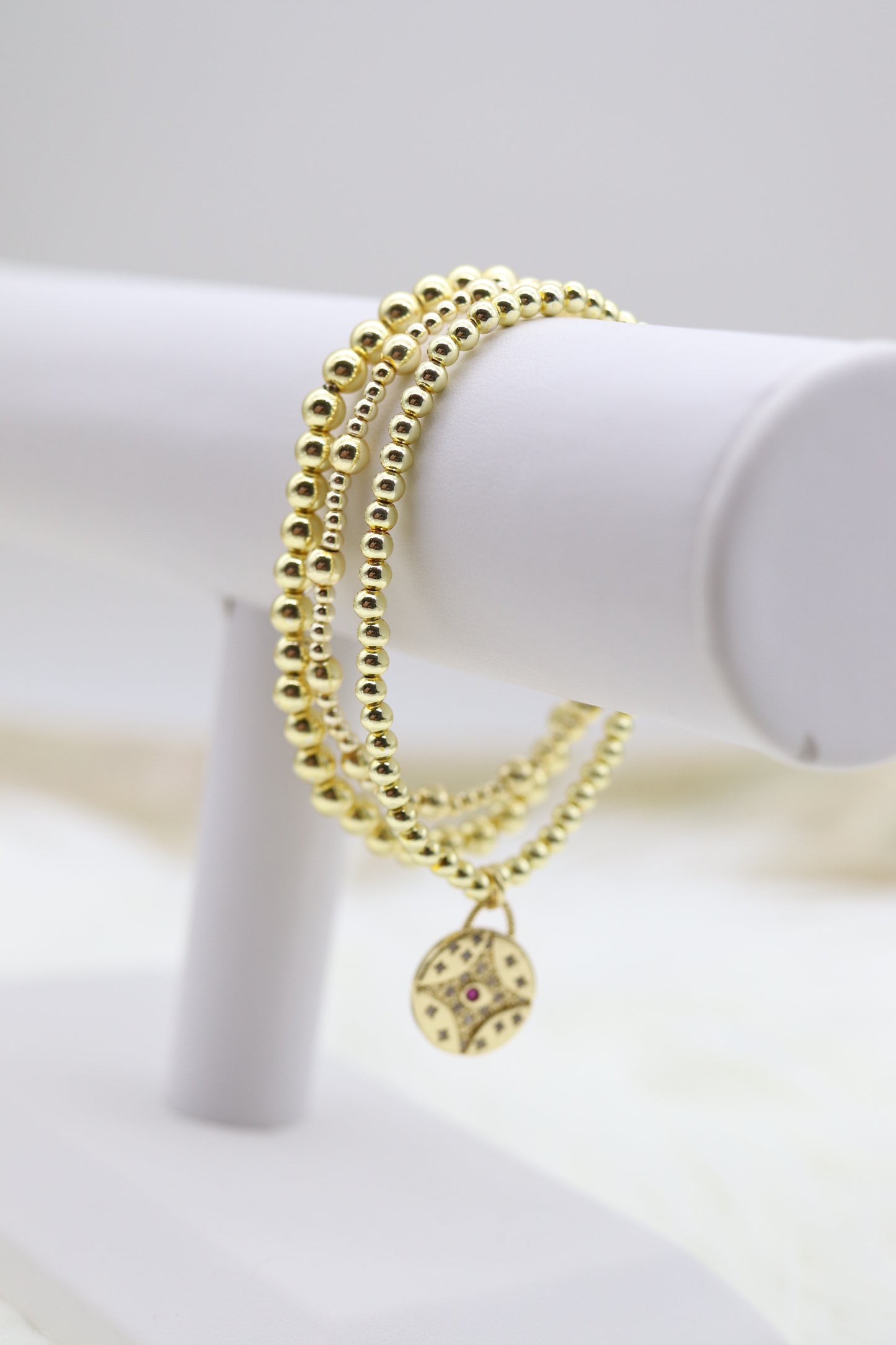 Triple Layered Gold Beaded Bracelet With Red Diamond Star Dangling Pendant