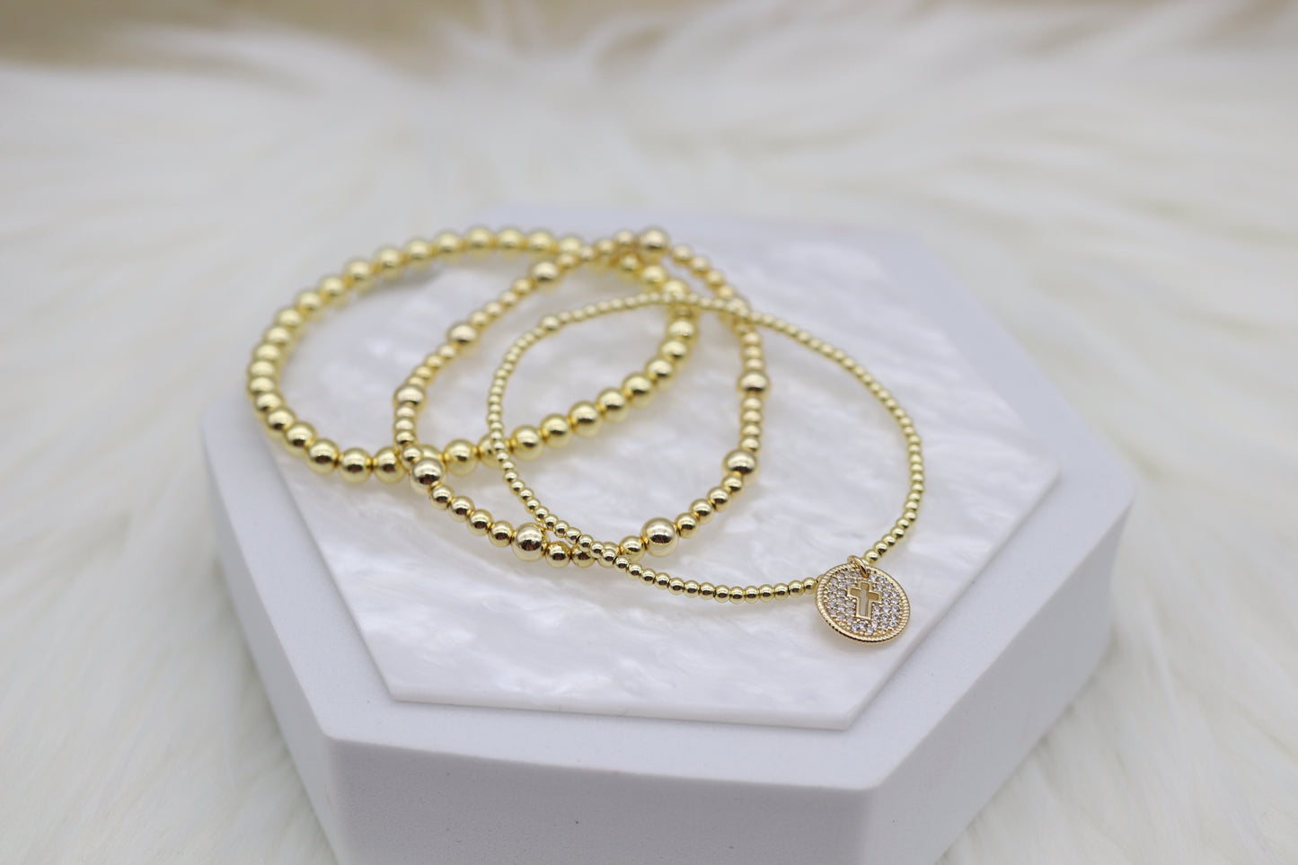 Triple Layered Gold Beaded Bracelet With Smaller Cross Dangling Pendant