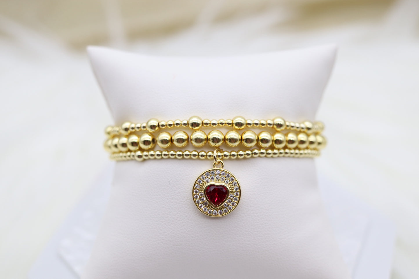Triple Layered Gold Beaded Bracelet With Red Heart Dangling Pendant
