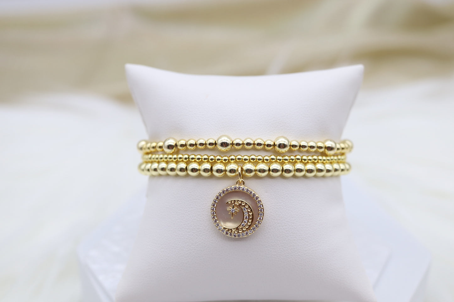 Triple Layered Gold Beaded Bracelet With Half Moon Dangling Pendant