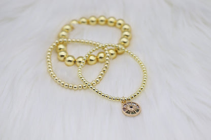 Triple Layered Gold Beaded Elastic Bracelet With Starburst Dangling Pendant