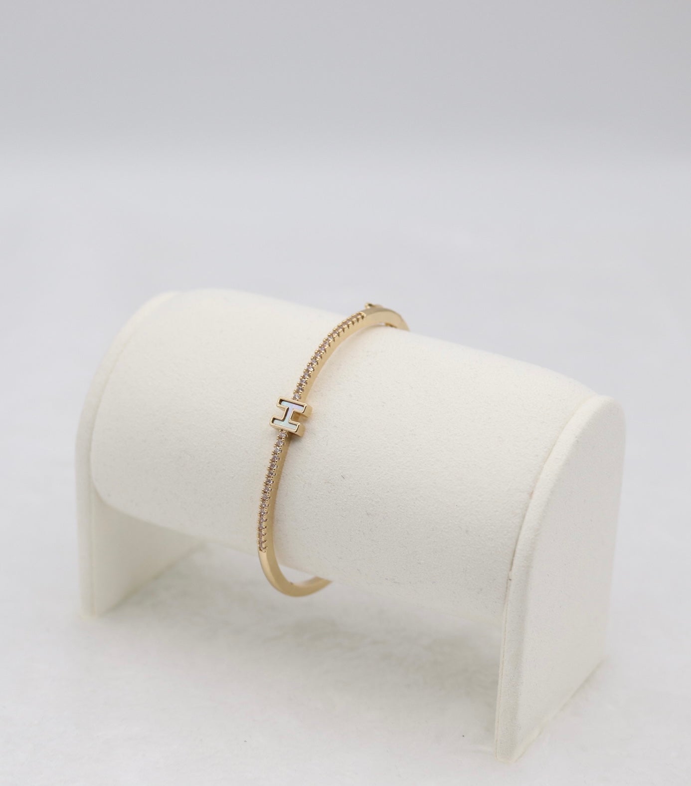Gold-Tone Hinged Bangle with Crystal Accents and “H” Centerpiece