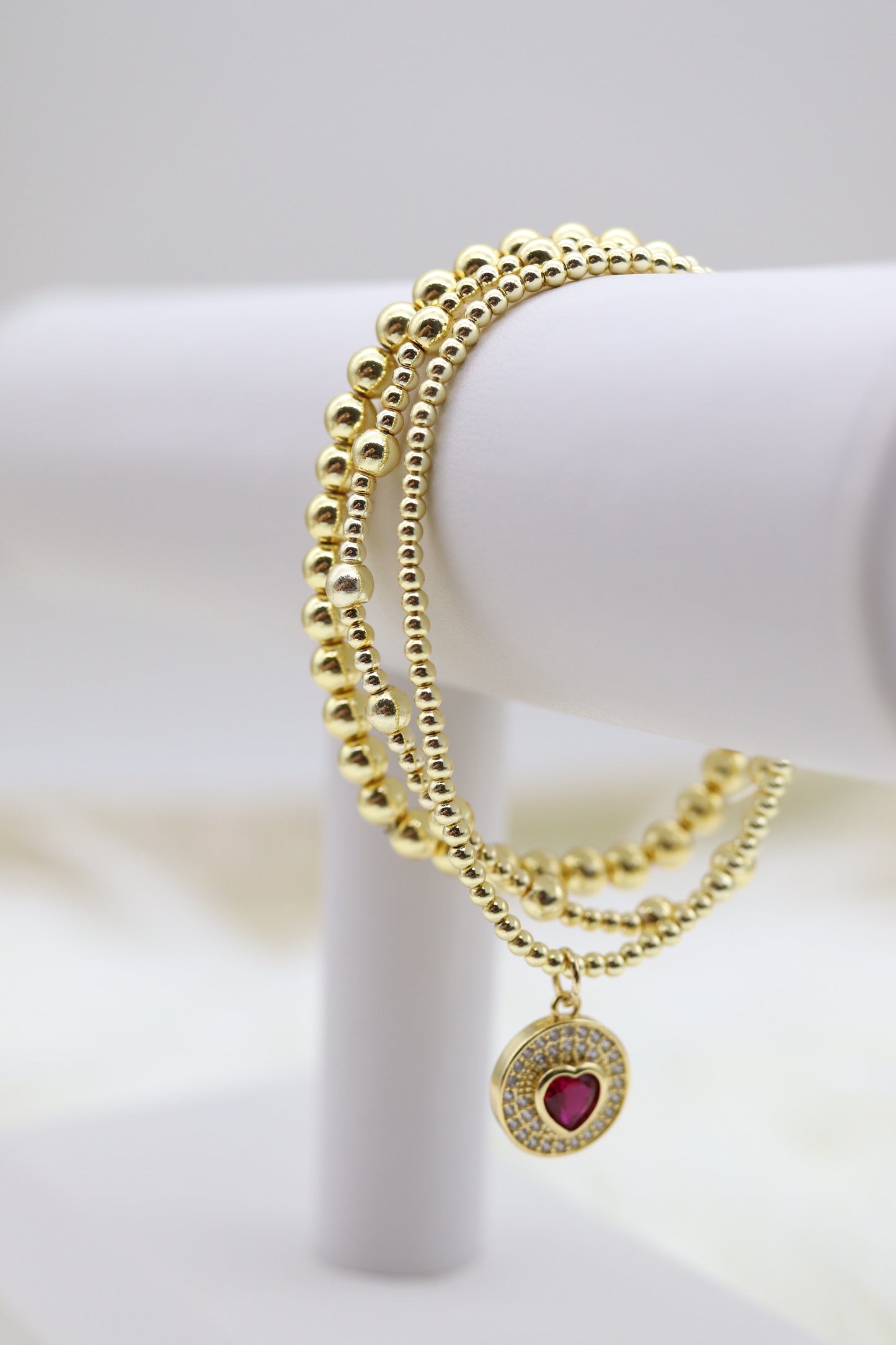 Triple Layered Gold Beaded Bracelet With Red Heart Dangling Pendant