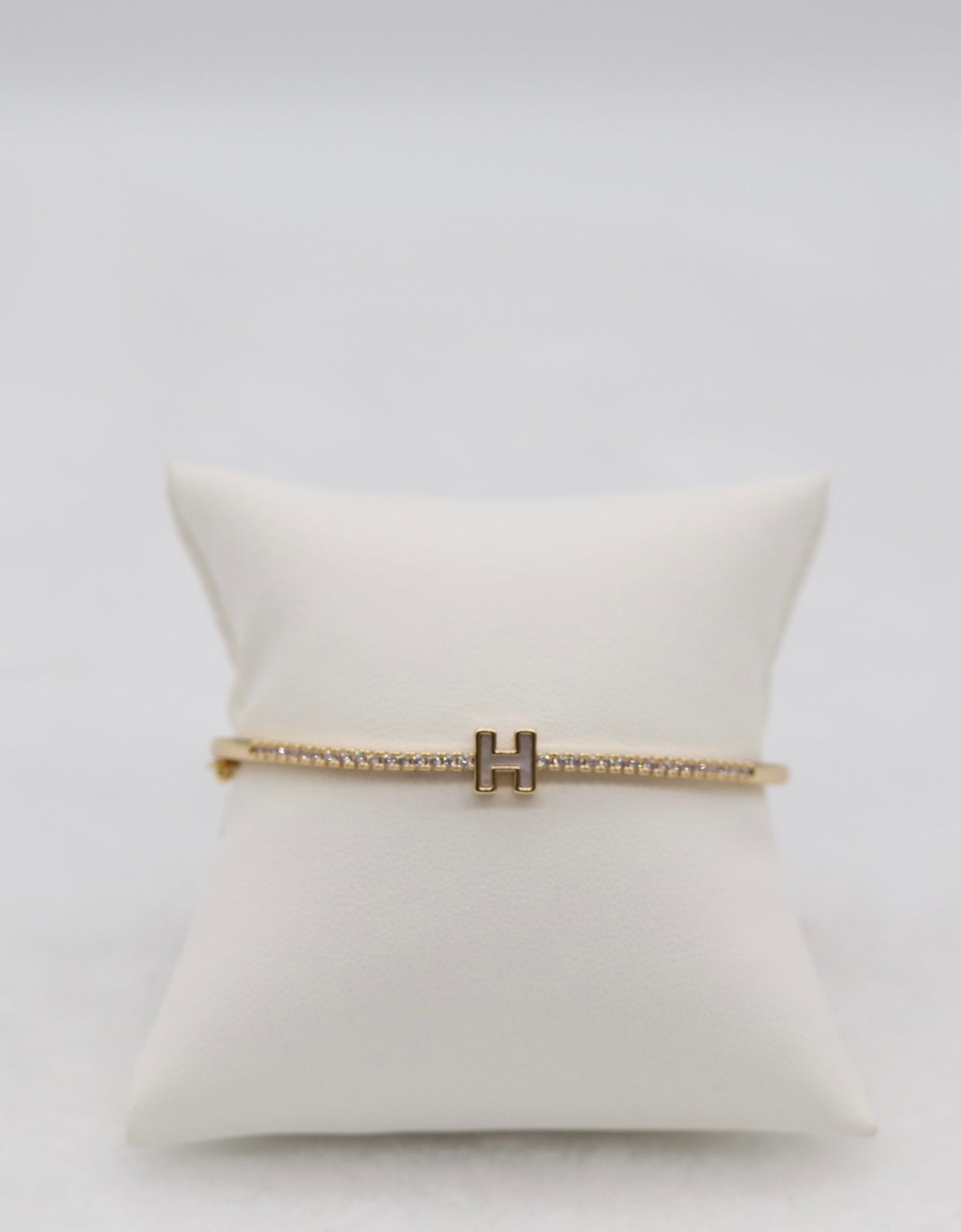 Gold-Tone Hinged Bangle with Crystal Accents and “H” Centerpiece