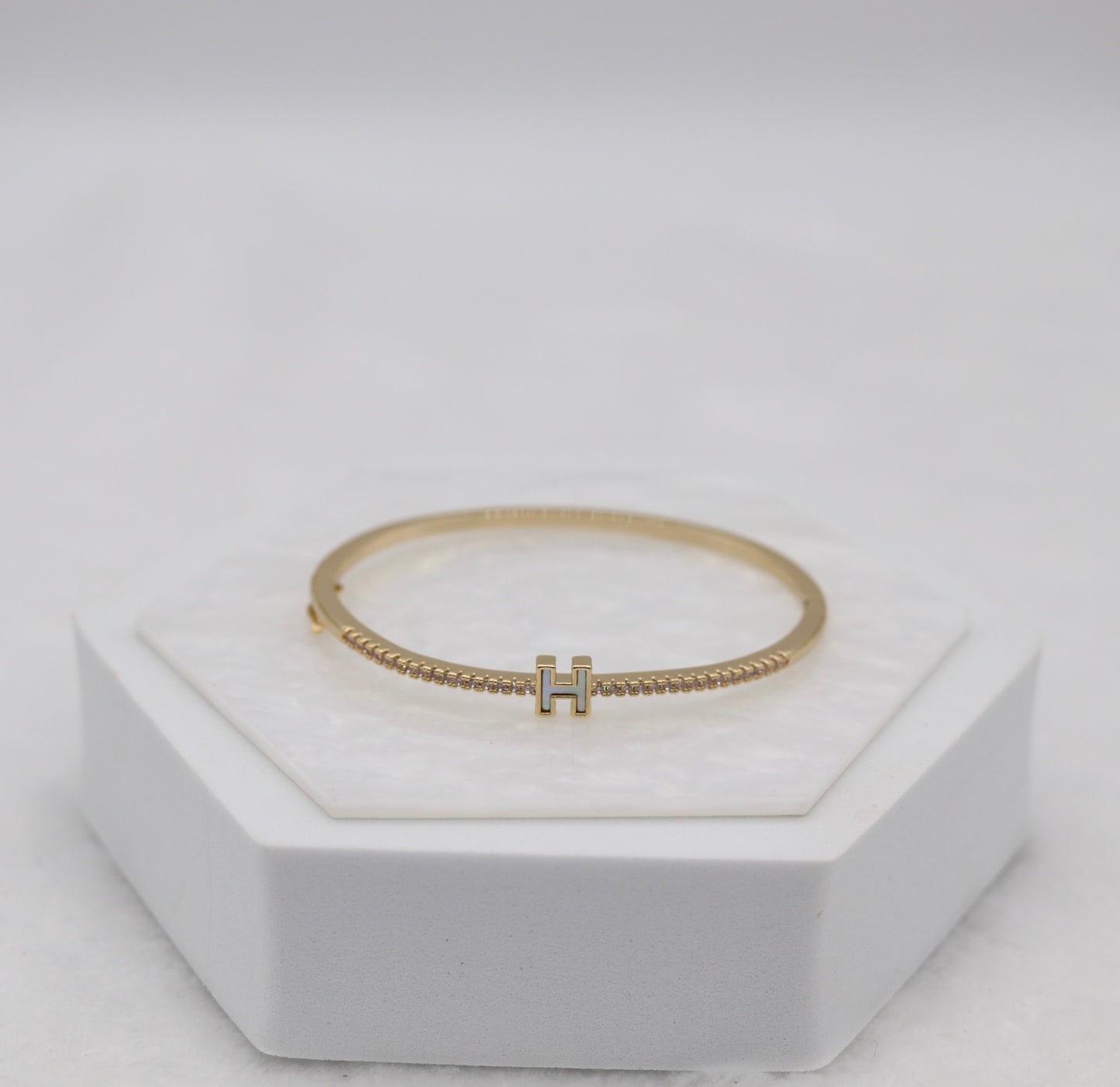 Gold-Tone Hinged Bangle with Crystal Accents and “H” Centerpiece