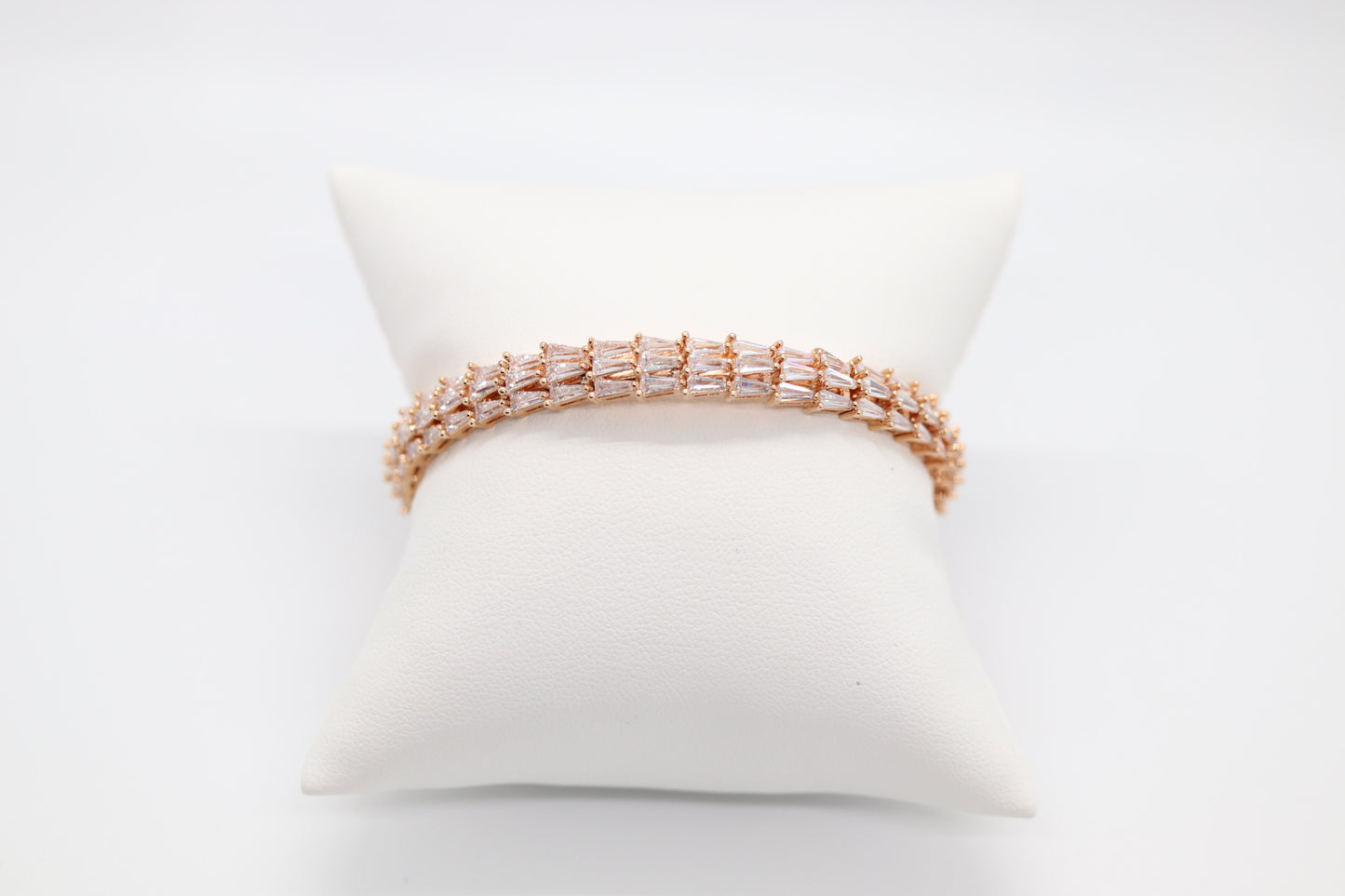 Triple Row Rose Gold bracelet with tapered baqueets and has hinge.