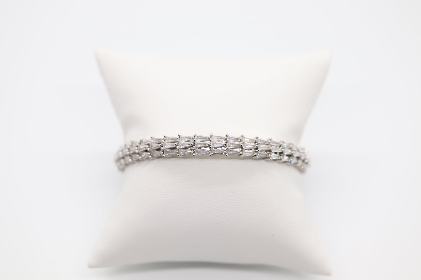 Triple Row Silver bracelet with tapered baqueets and has hinge.